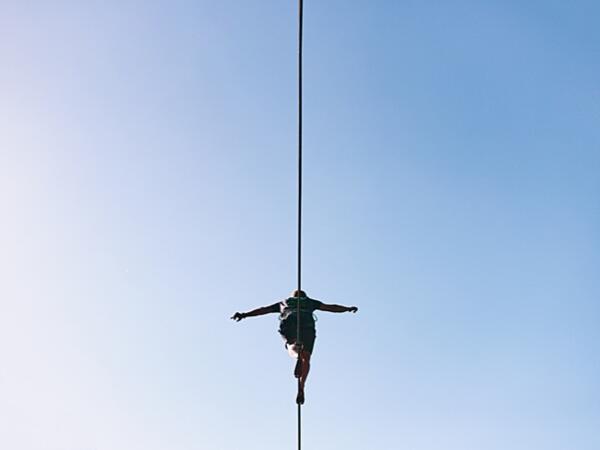 person walking on tightrope against blue sky